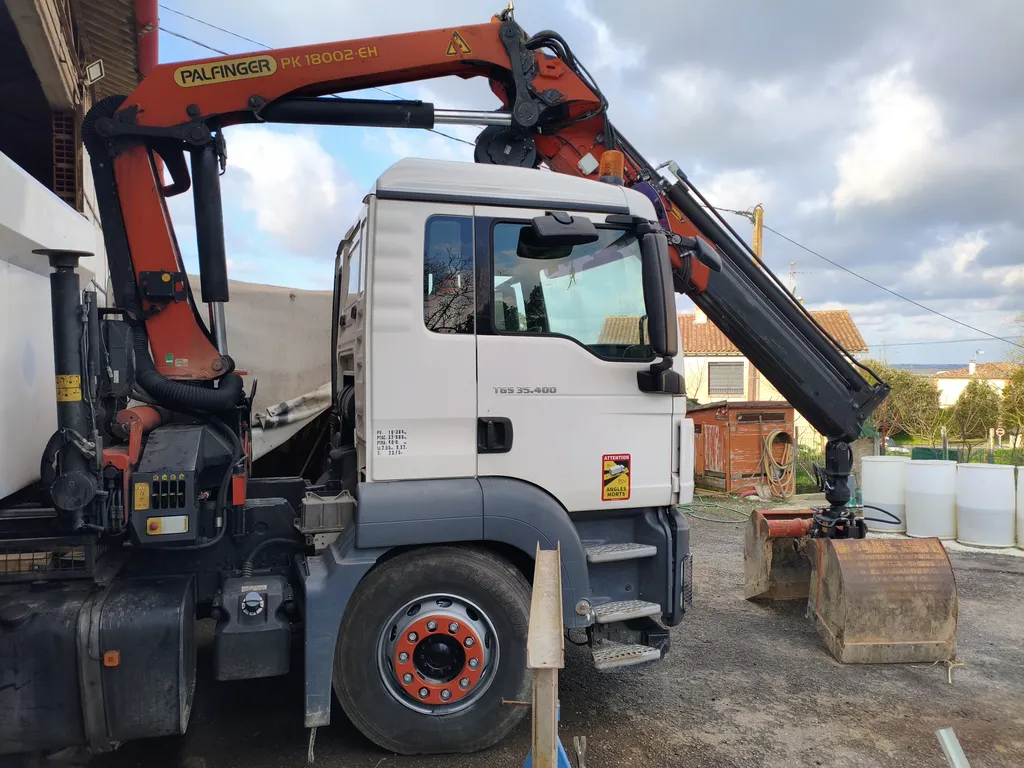 Grue hydraulique Palfinger déployée avec pince